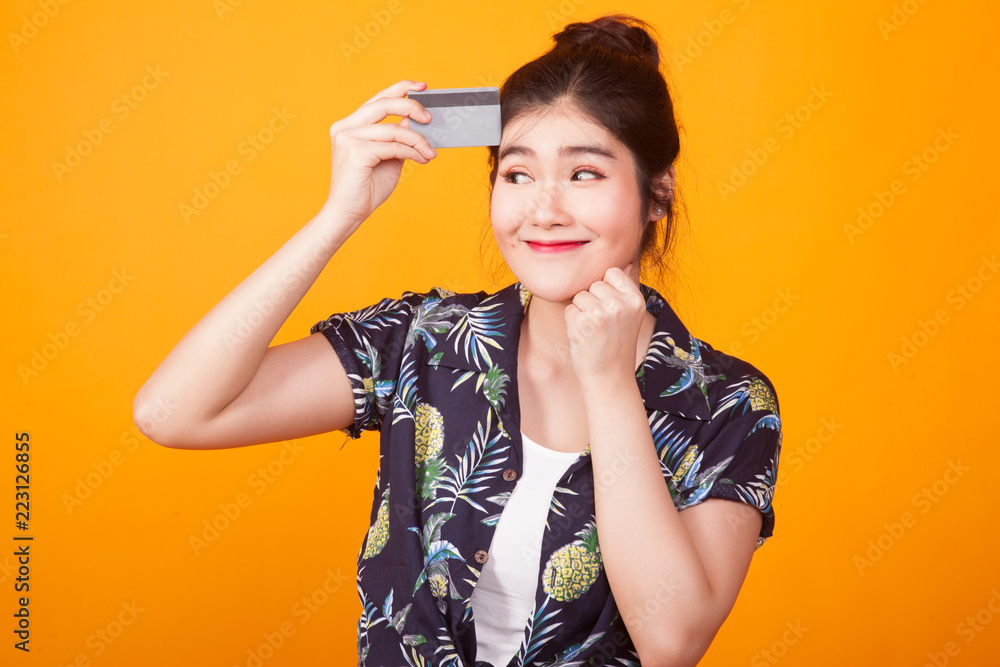 Young Asian woman think with a blank card in tropical shirt Young Asian woman think with a blank card in tropical shirt
