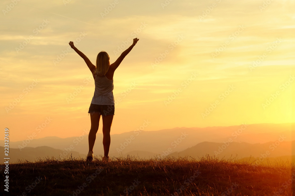 Happy woman with open arms stay on the peak of the mountain clif Happy woman with open arms stay on the peak of the mountain clif
