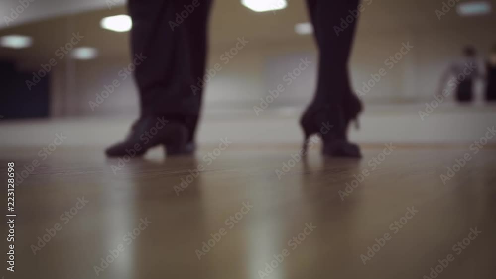 Dancing male and female legs in the dance studio Dancing male and female legs in the dance studio