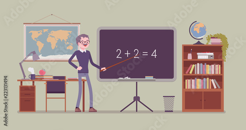 Male teacher stands at the blackboard