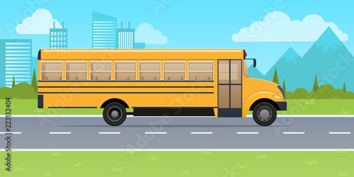 Classic yellow school bus, on background of urban high-rise buildings.