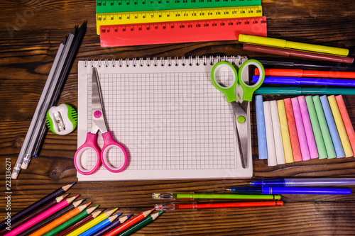 Different school stationeries on a dark wooden table. Top view