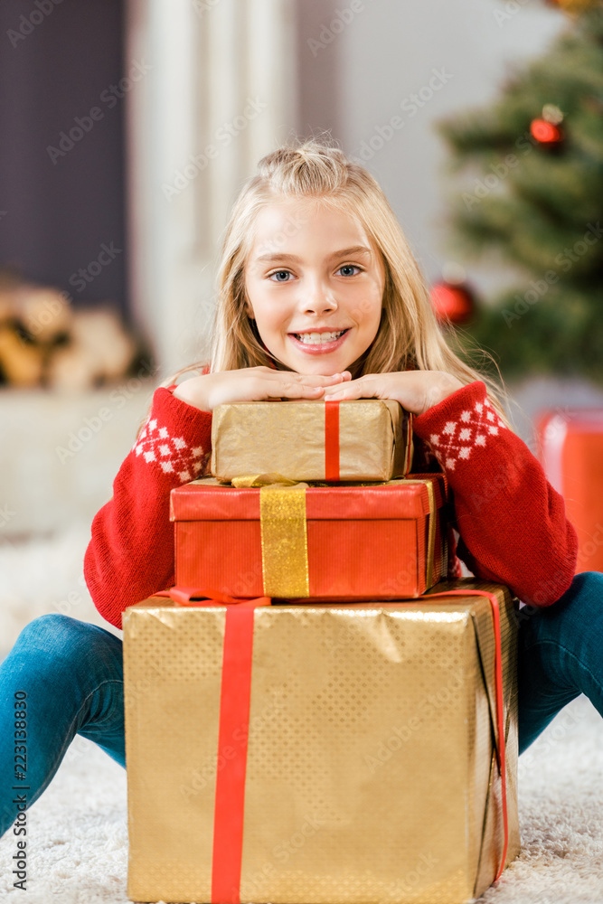 adorable happy child leaning on stack of christmas gift boxes adorable happy child leaning on stack of christmas gift boxes