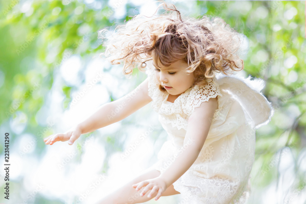Beautiful little Angel girl flying at the forest