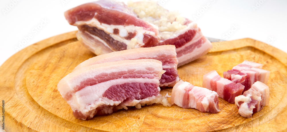 National Russian and Ukrainian food is salo. Sliced bacon on a wooden board. On a white background.