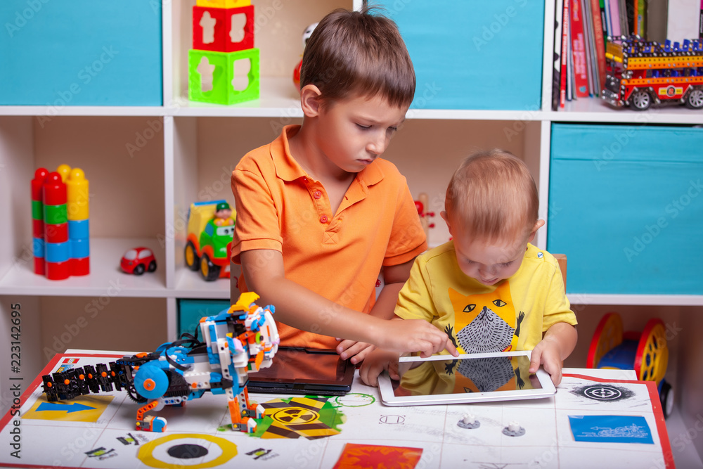 Fototapeta premium Two boys ?hild collects robot from the plastics details