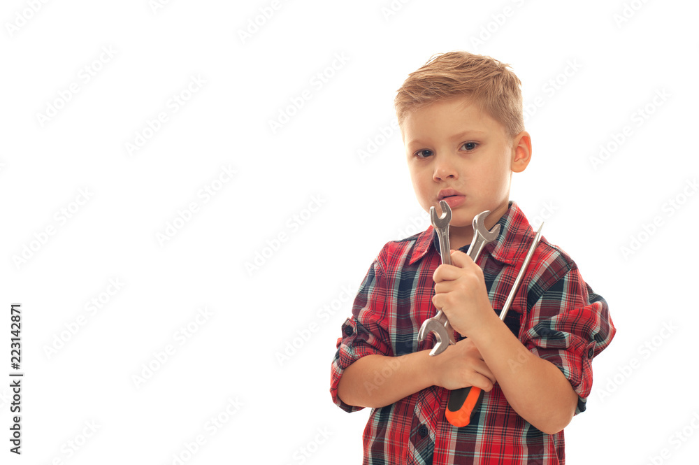 Portrait of serious little boy handyman wearing plaid shirt with wrenches in hands. Portrait of serious little boy handyman wearing plaid shirt with wrenches in hands.