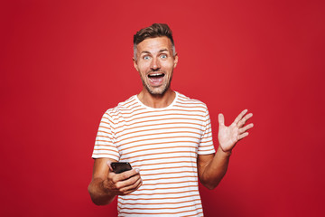Portrait of an excited man standing over red background