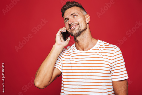 Portrait of a smiling man standing over red background