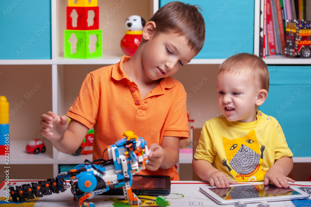 Fototapeta premium Two boys ?hild collects robot from the plastics details