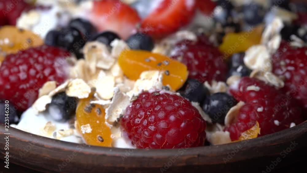 Cereal flakes with blueberries, raspberries, strawberries and cherry plums rotating . Crunchy tasty muesli food background close-up. Cereals, berry and dried food mixed for breakfast Cereal flakes with blueberries, raspberries, strawberries and cherry plums rotating . Crunchy tasty muesli food background close-up. Cereals, berry and dried food mixed for breakfast
