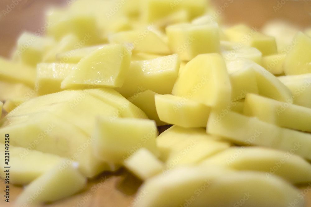 Sliced, peeled raw potatoes on a board. potato preparation process Sliced, peeled raw potatoes on a board. potato preparation process