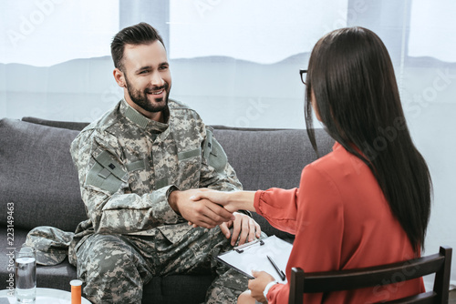 Canvastavla smiling soldier shaking hand of psychiatrist during therapy session