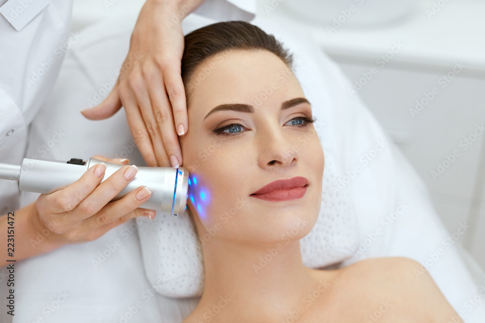 Beauty. Woman Doing Blue Light Facial Treatment On Face Skin