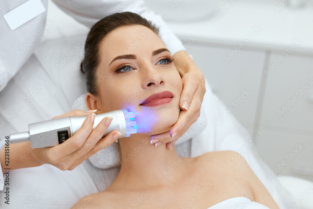 Face Skin Cosmetology. Closeup Woman Doing Blue Light Treatment Face Skin Cosmetology. Closeup Woman Doing Blue Light Treatment