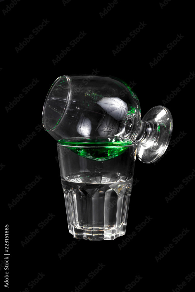 Cocktail with absinthe and tonic, syrup, glass on the glass, on each other isolated black backdrop, for the menu of the bar, restaurant, club, cafe Cocktail with absinthe and tonic, syrup, glass on the glass, on each other isolated black backdrop, for the menu of the bar, restaurant, club, cafe
