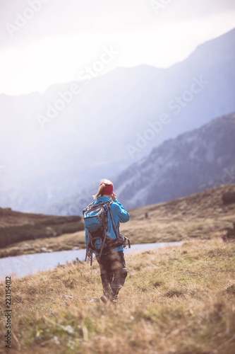 Junge Frau mit Rucksack wandert in den Alpen  Alpensee
