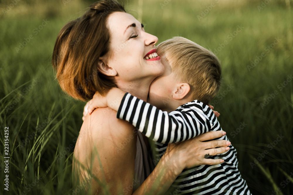 portrait of mother and son sitting in green grass portrait of mother and son sitting in green grass