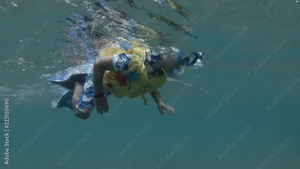 Little boy in mask, snorkel and fins swim on the surface of water (underwater shot, 4K / 60fps)
Little boy in mask, snorkel and fins swim on the surface of water (underwater shot, 4K / 60fps)