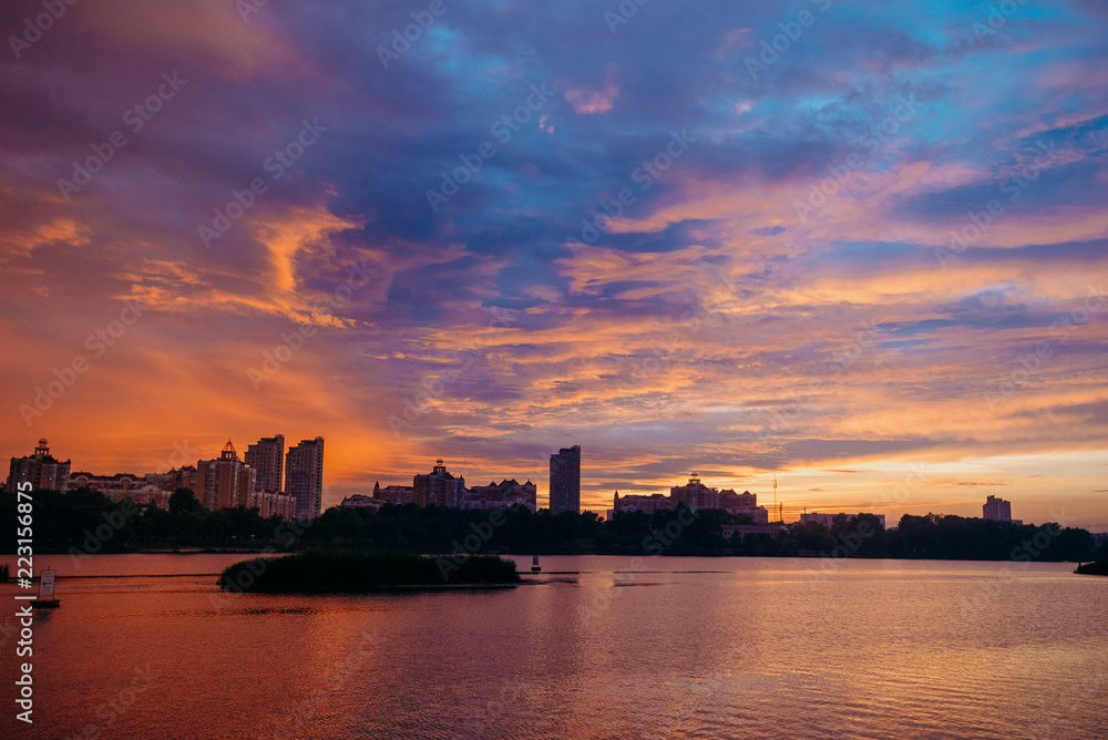 View of the city center midtown silhouette from the river at color sunset. text place