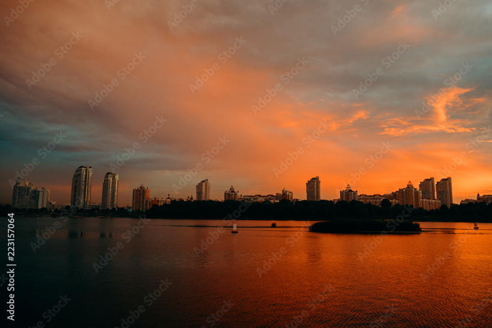 View of the city center midtown silhouette from the river at color sunset. text place