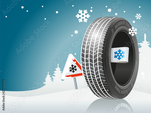 The winter tire is ready to the winter road. An automobile tire against the background of snow and the sign about the snow road.