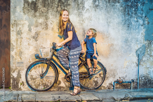 Mother and son on a bicycle. Public street art Name Children on a bicycle painted 3D on the wall that's two little Chinese girls riding bicycle in Georgetown, Penang, Malaysia photo