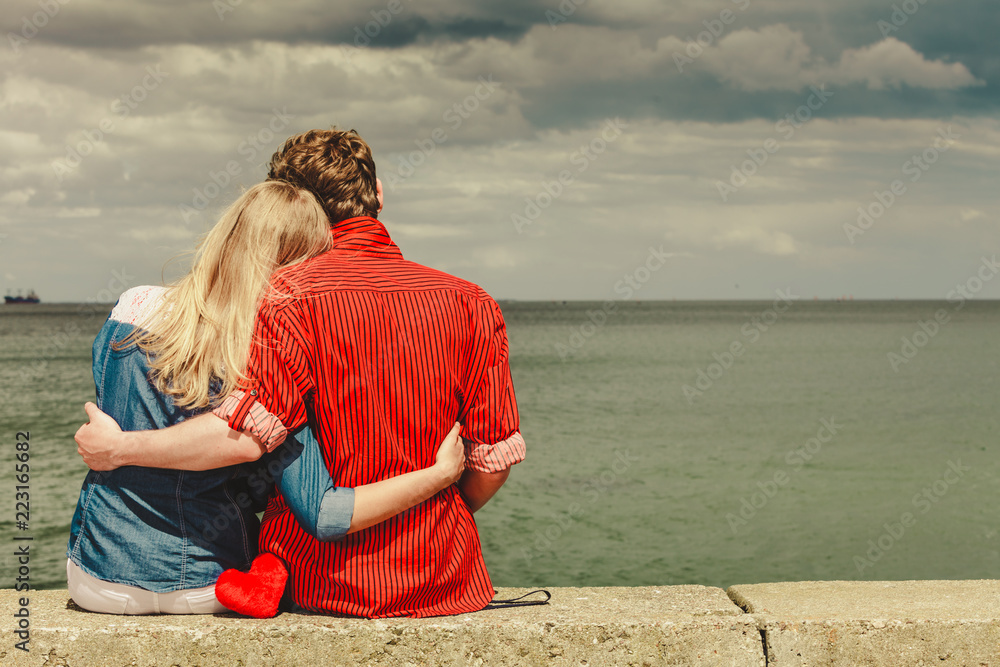 Fototapeta premium Couple sitting hugged on sea shore