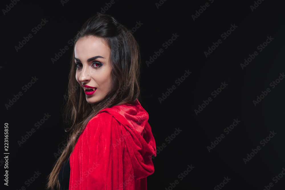 sexy vampire woman in red cloak isolated on black