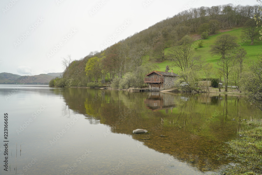 Obraz premium a view of pooley bridge boat house with a green hill background at ullswater lake in lake district national park united kingdom