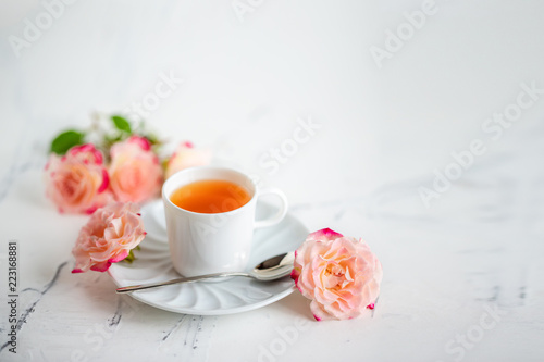 cup of tea with roses on a light background