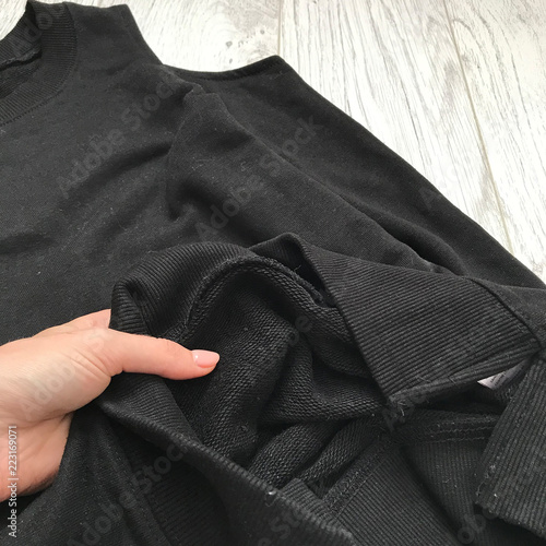 Details of a black sweatshirt on a wooden background