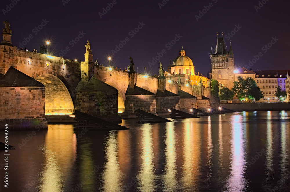 Summer night view of historical part of Prague. Vltava river, Mala Strana Bridge Tower and Charles Bridge with illumination. Prague, Czech Republic