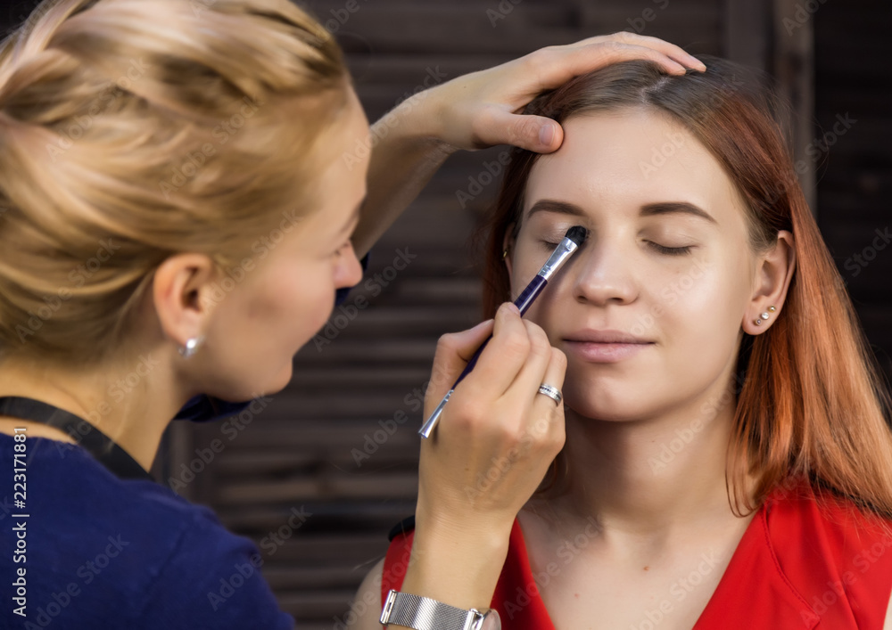 makeup artist preparing young beautiful woman. close-up eyeliner makeup artist preparing young beautiful woman. close-up eyeliner