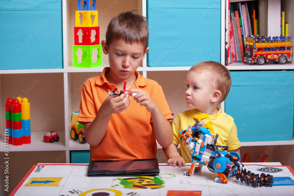 Fototapeta premium Two boys ?hild collects robot from the plastics details