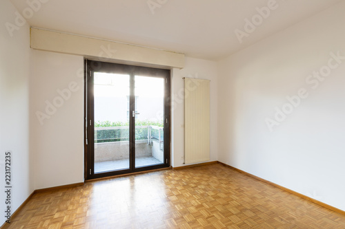 Empty room with window and parquet