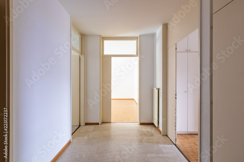 White corridor with parquet and open doors.