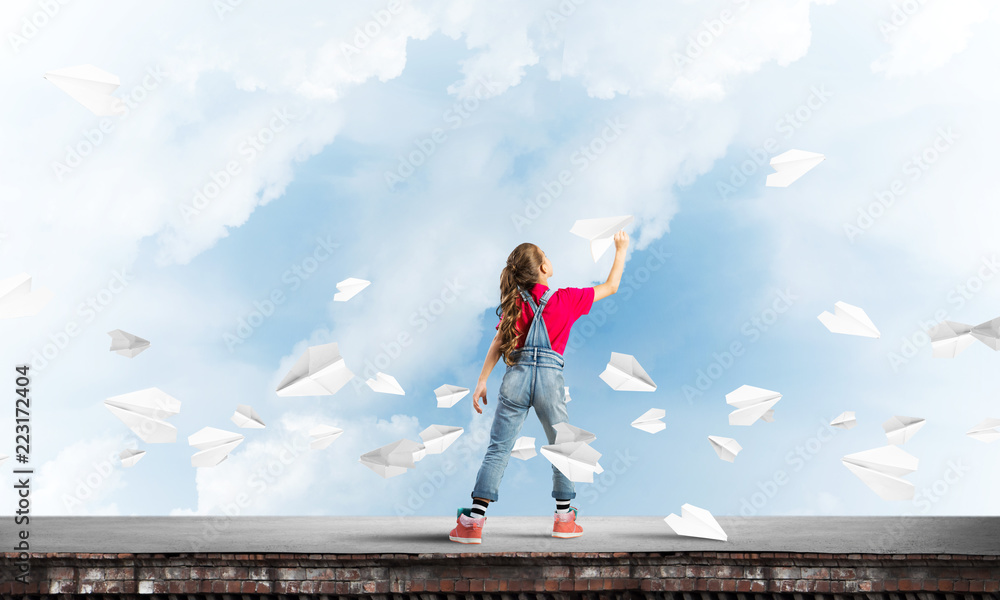 Concept of careless happy childhood with girl dreaming to become pilot Concept of careless happy childhood with girl dreaming to become pilot
