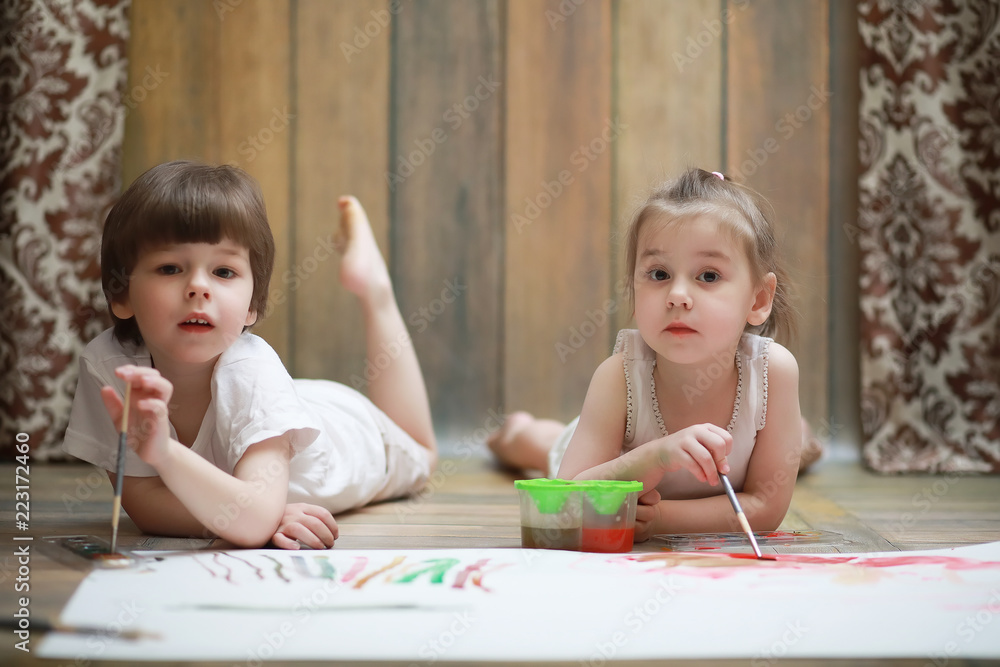 Little children paint on a large sheet of paper Little children paint on a large sheet of paper