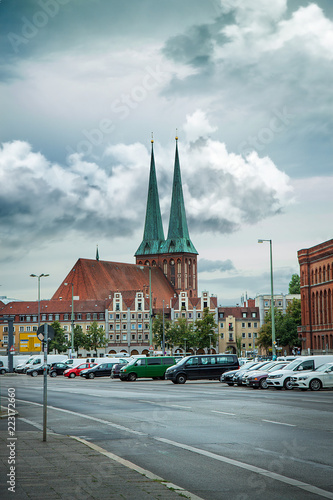 Old church in Berlin. Germany. Beautiful cityscape, street, parking, cars. Ordinary city life.