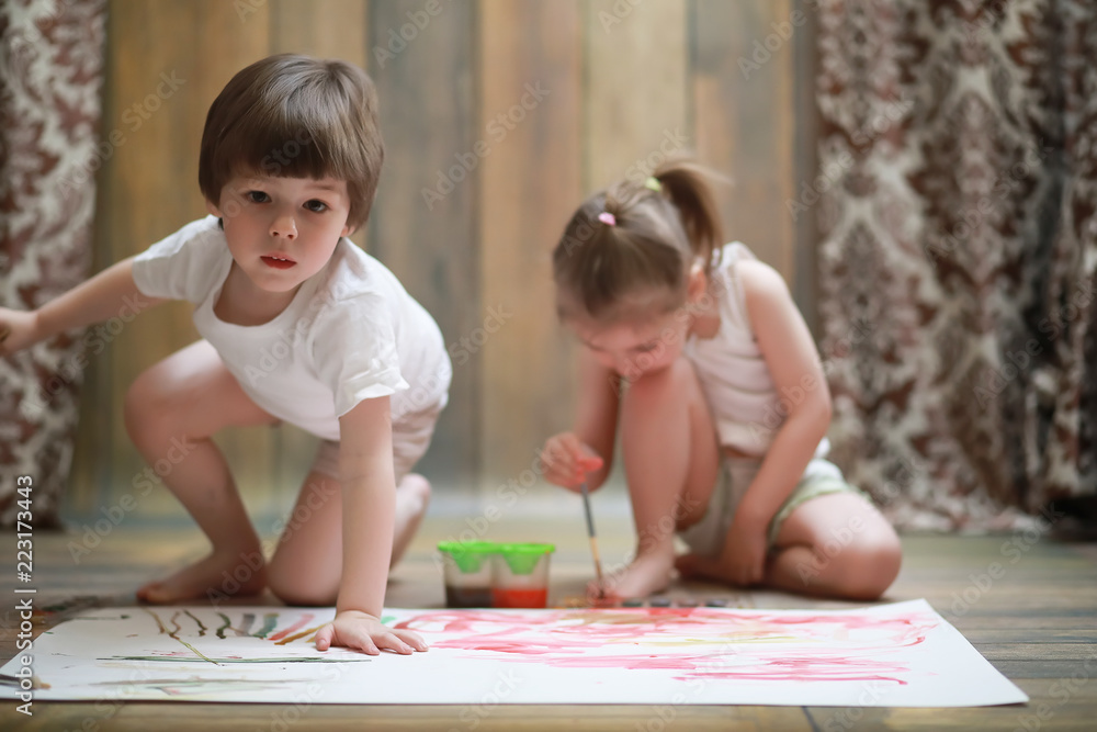 Little children paint on a large sheet of paper Little children paint on a large sheet of paper