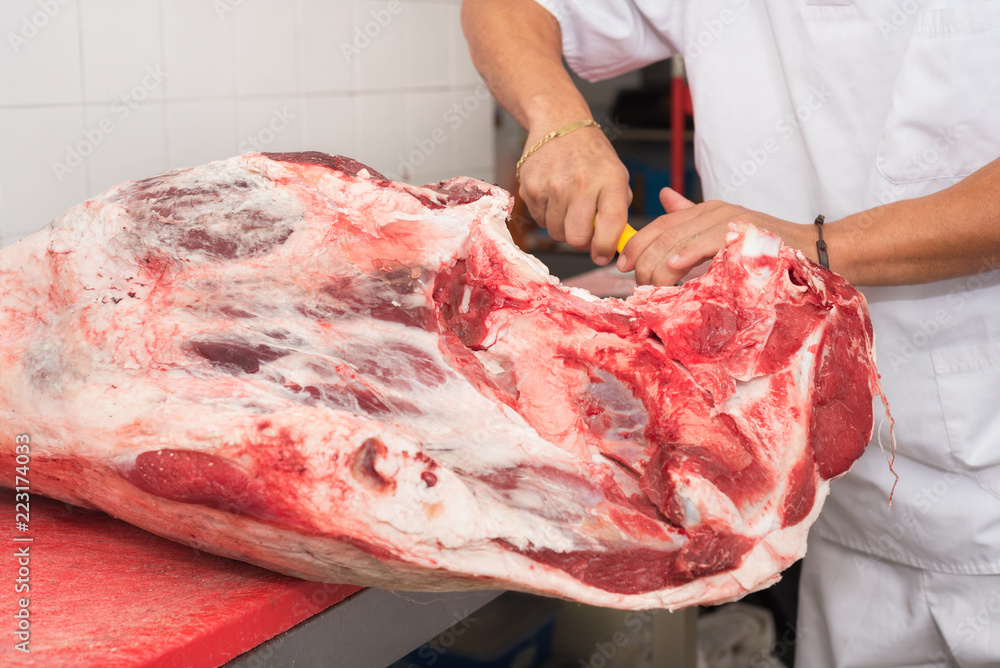 butcher cutting meat in the butchery. Close up