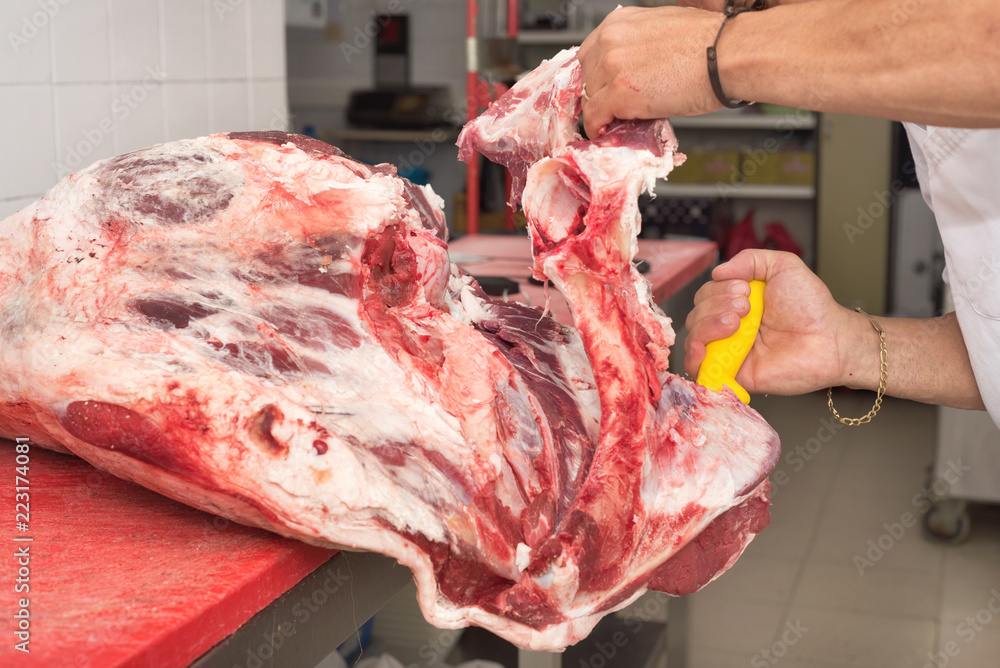 butcher cutting meat in the butchery. Close up