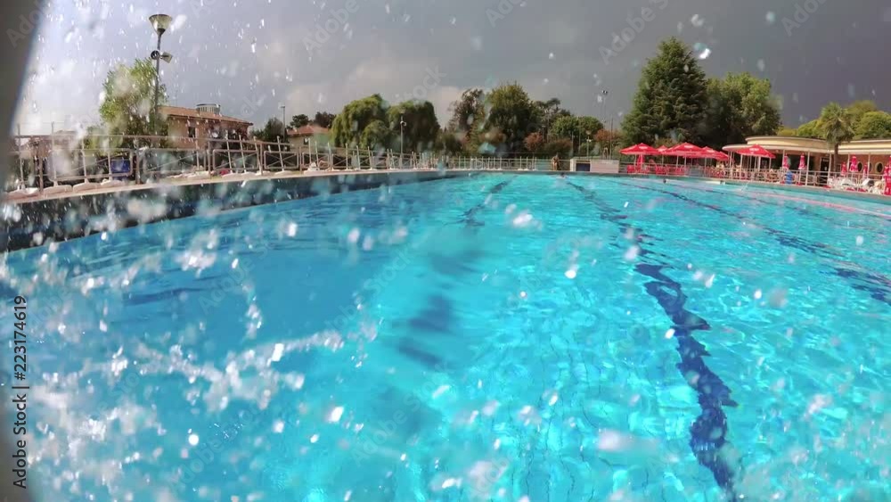 The teenager swims in the pool under the water. The teenager swims in the pool under the water.