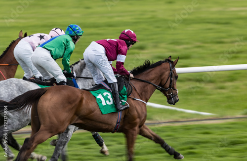 Race horses and jockeys sprint towards the finish line, Panning motion blur effect