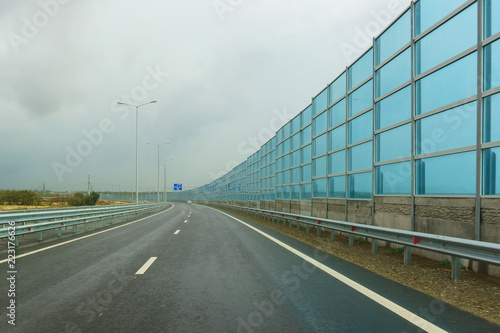 Noise-absorbing screens on the new road A-290 (formerly M25) on the Taman Peninsula on a cloudy autumn day © garmashevanatali