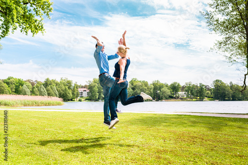 Fototapeta Young modern couple giving hi five to eachother in the park