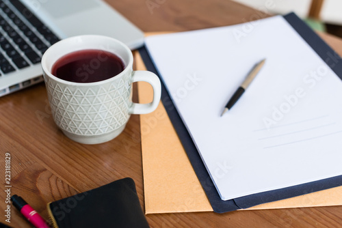 Close-up of coffee cup and documents on desk