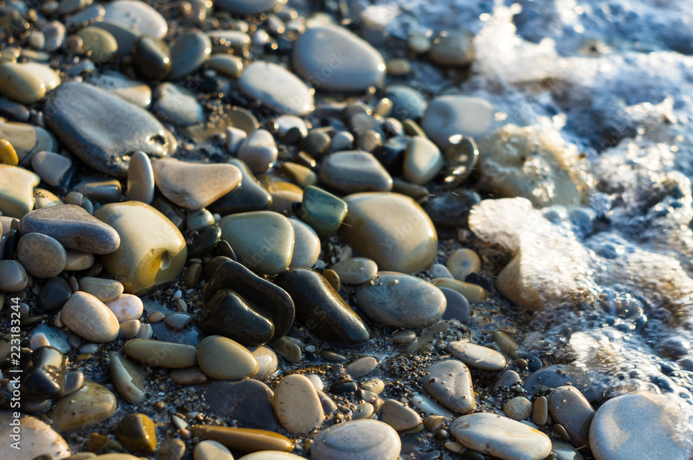 pebble stones on the sea beach, the rolling waves of the sea with foam pebble stones on the sea beach, the rolling waves of the sea with foam