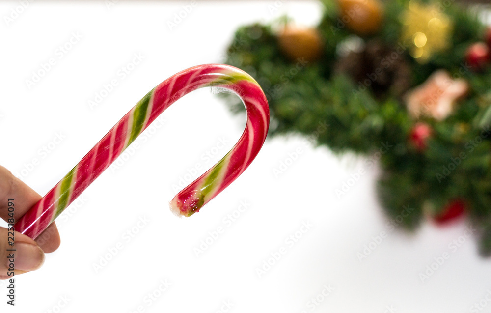 Fototapeta premium Striped christmas red candy cane isolated on white background and decorations. Winter holidays. Christmas and new year traditional sweets. Winter atmosphere, theme concept. Red, green, gold color.